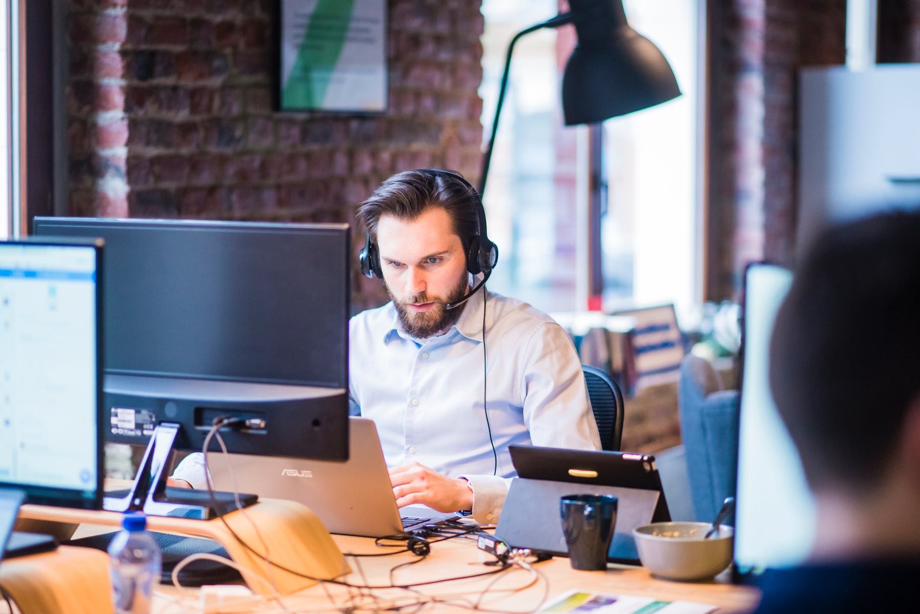 man at desk with phone system